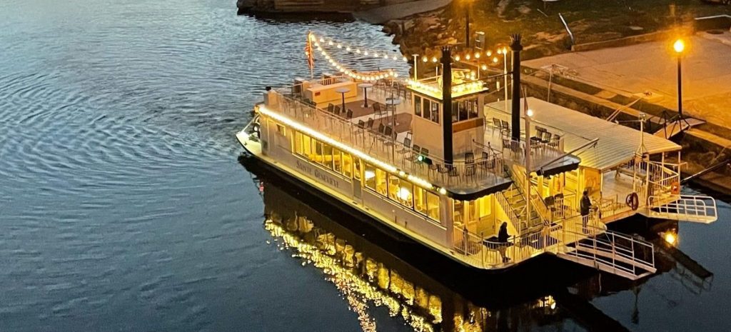 The St. Genevieve Riverboat at dusk with its decorative night lights on
